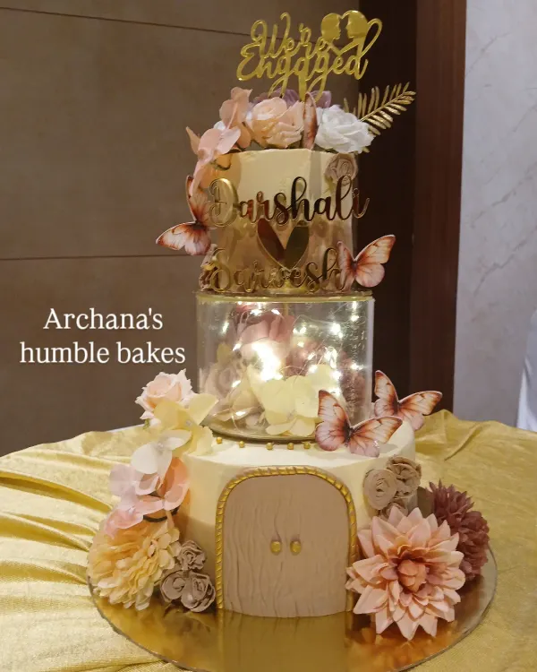 This three-tiered spacer cake was the centerpiece for a beautiful engagement party. The clear separator filled with fairy lights and flowers adds a touch of magic, making it a truly modern and elegant celebration cake.