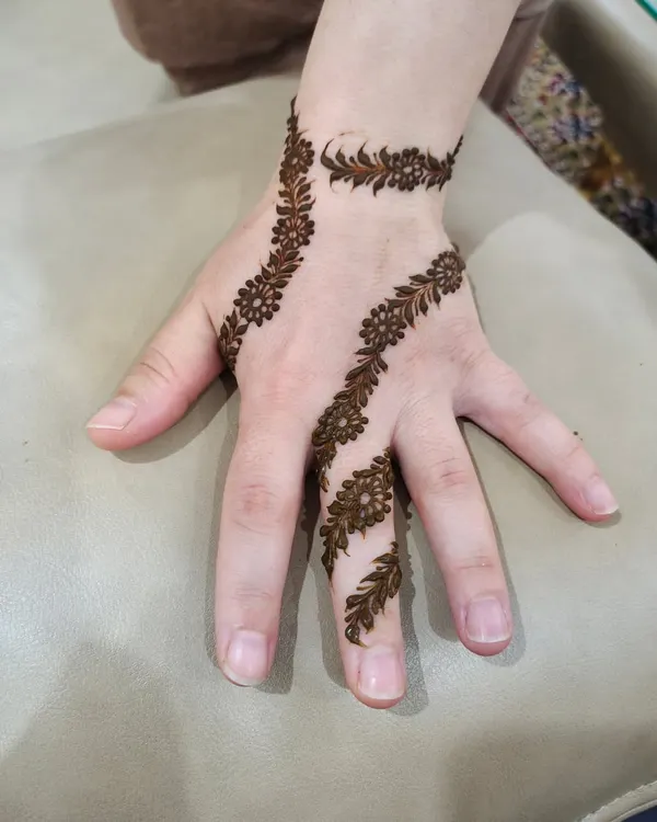 A simple yet elegant leafy vine that wraps around the finger and across the hand. This minimalist design was created for a bride from Turkey.