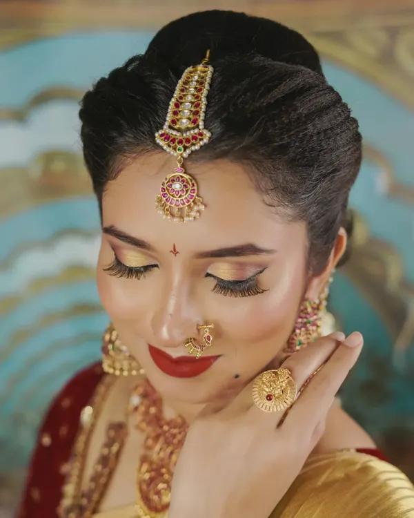 A close-up of this gorgeous bridal set. The rental includes the detailed maang tikka, a traditional nose ring (nath), and jhumkas that perfectly frame the face for those all-important wedding photos.