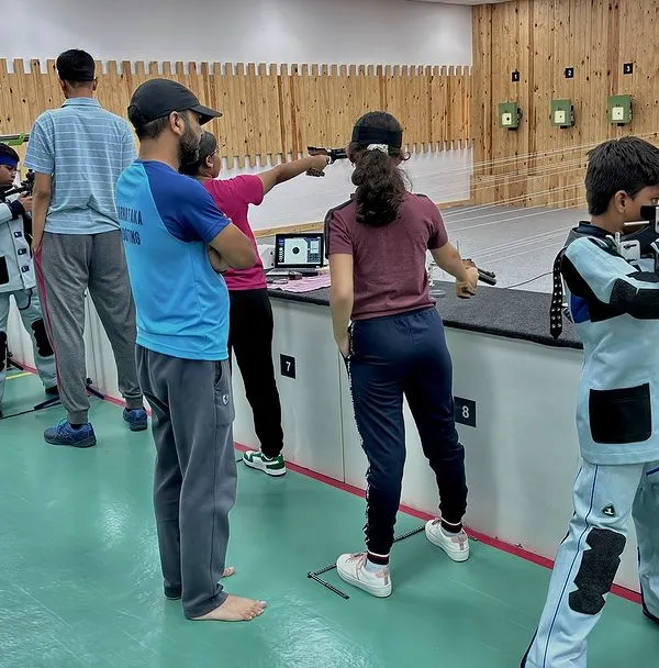 Our state-of-the-art shooting range is where future champions are made. This image captures a typical training session, with young shooters in full gear learning the fundamentals of air rifle shooting under the watchful eye of our certified coaches.