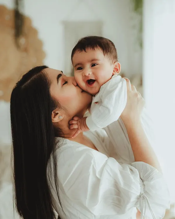 The purest joy in a single photo! A mother gets a happy kiss from her baby in this light-filled, candid moment that is overflowing with love.