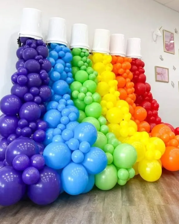 A creative and colorful balloon installation designed to look like paint spilling from buckets, perfect for an art-themed party or a vibrant celebration.
