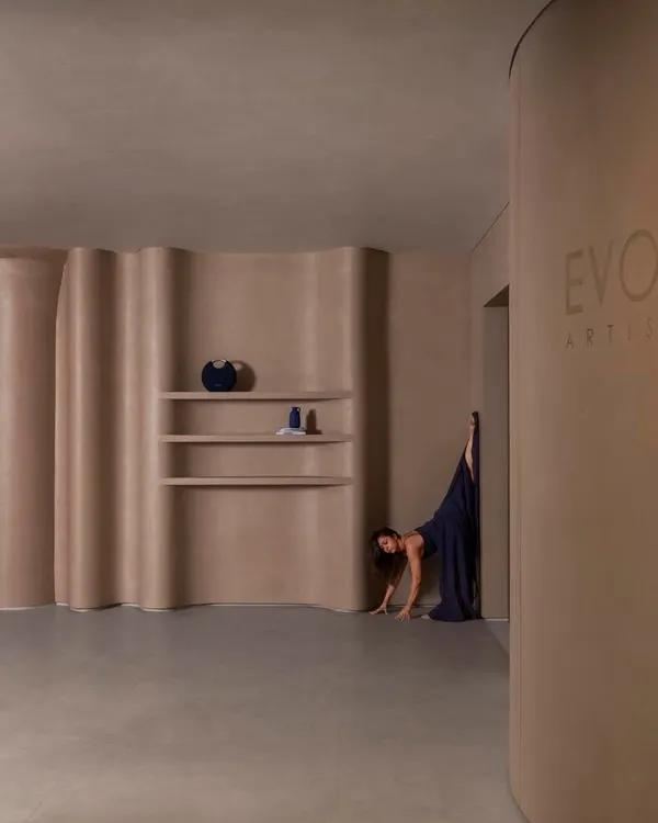 This experiential showroom in Mumbai by ACKM Studio uses curved, flowing walls and minimalist shelving to create a space that feels like a contemporary art gallery.