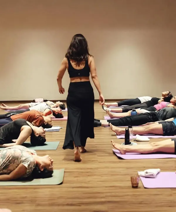 A class in Savasana, the final resting pose. This is a moment of collective surrender, where the benefits of the practice are absorbed in stillness.