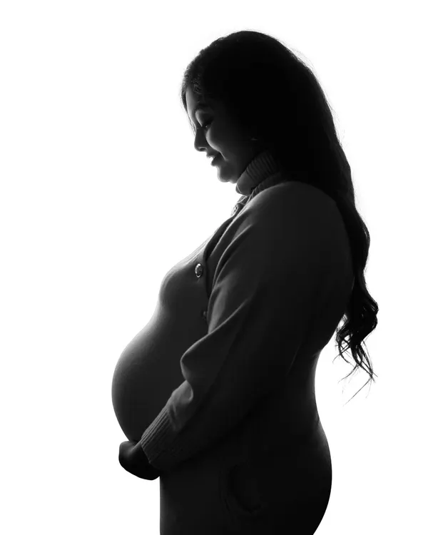 A simple, powerful silhouette. This high-contrast, black and white image beautifully highlights the profile of the mom-to-be, focusing on the incredible shape of pregnancy.