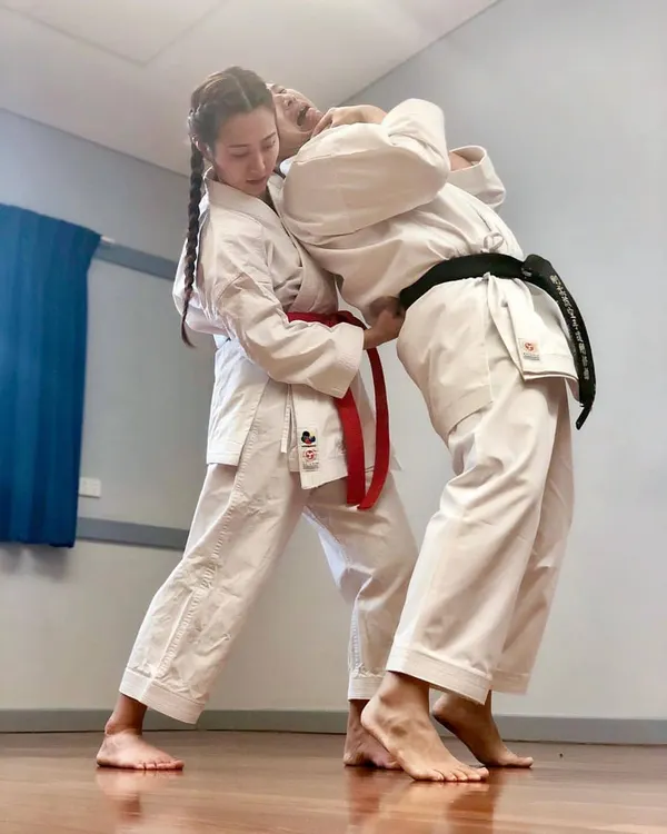 This is not a movie stunt; it's effective self-defense. Here, a student practices a throw, a key technique in our women's self-defense workshops for neutralizing a threat.