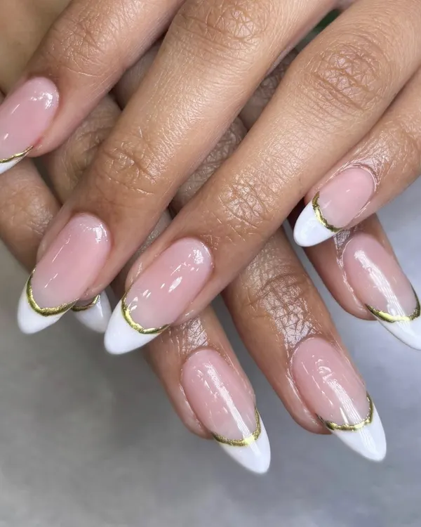 A close-up of the modern French manicure with a delicate gold chrome line. This detail adds a touch of luxury and sophistication to the timeless style.