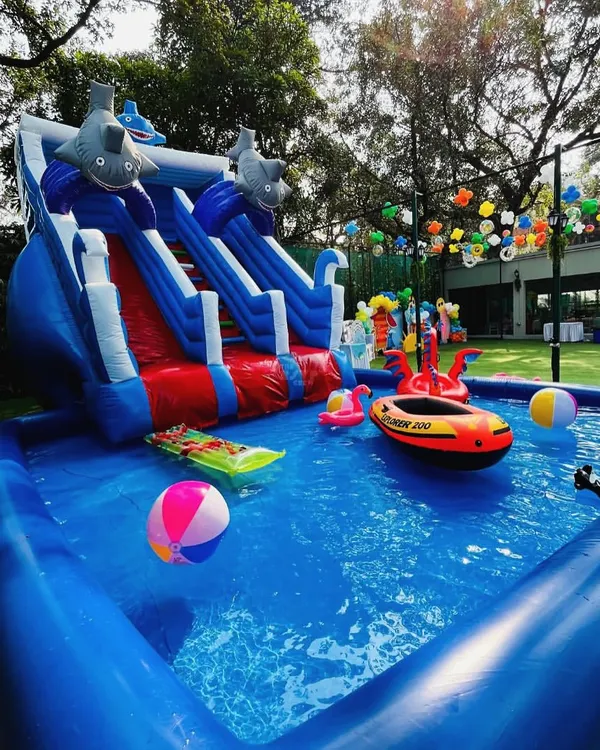 Making a splash! This pool party setup includes a large inflatable pool with a water slide, perfect for cooling off and having fun in the sun.