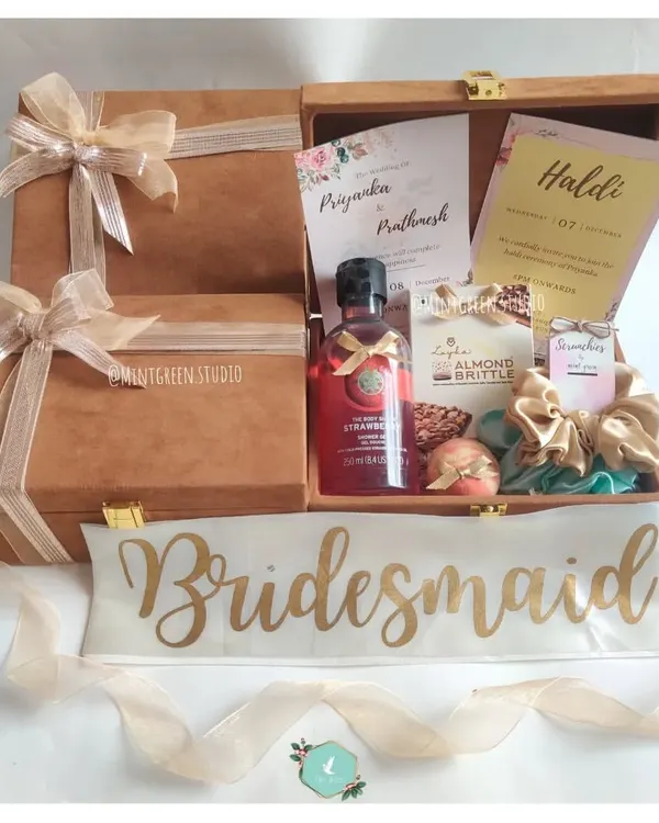 A beautiful bridesmaid proposal hamper. The suede box includes a "Bridesmaid" sash, a wedding invitation, and pampering products to make her feel special.