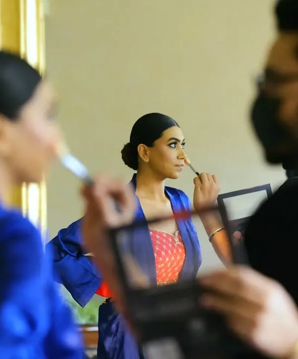 "Soon to be Mrs." A behind-the-scenes shot of the bride getting her makeup done, captured through a reflection. This shows the process and the team that helps create the final look.