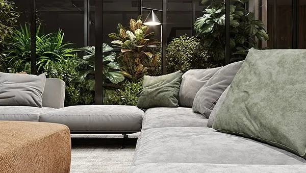 A close-up of a comfortable sofa set against a backdrop of a lush, enclosed indoor garden. This design brings the restorative feeling of nature right into the living area without sacrificing comfort or space.