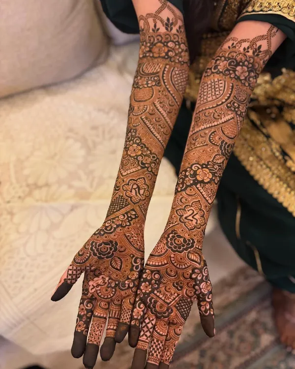 A full view of this personalized bridal mehendi, featuring the couple's initials 'R' and the number '24' beautifully integrated into the intricate Pakistani design.