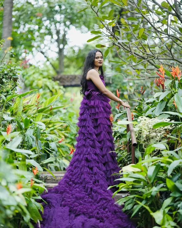 Make your pre-wedding shoot magical with a stunning gown. This purple ruffle gown with a long trail is perfect for creating dramatic and romantic photos in a beautiful garden setting.