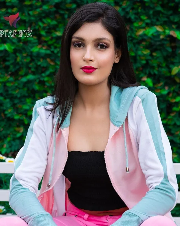 A relaxed, seated portrait taken outdoors against a lush green backdrop. This type of natural light photography is ideal for lifestyle brands, creating a relatable and approachable feel for casual wear catalogues.