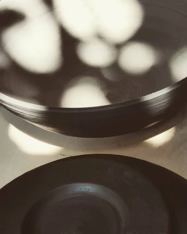 A stack of freshly thrown bowls catching the sunlight. There's such beauty in seeing a collection of work come together after a class.