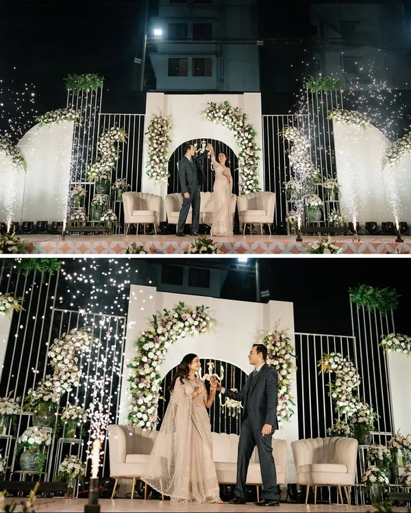 A champagne toast to forever. We created this grand reception stage with floral arches and cold pyro effects for a truly luxurious and celebratory entrance.
