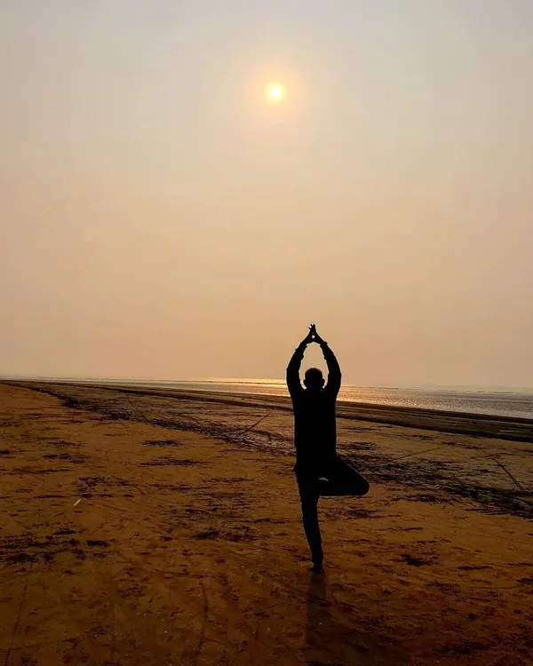 This is Vrikshasana, the Tree Pose, practiced at sunrise. This asana helps us find balance and stability, rooting down into the earth just like a tree. It reminds us that even with the world moving around us, we can find a steady center.