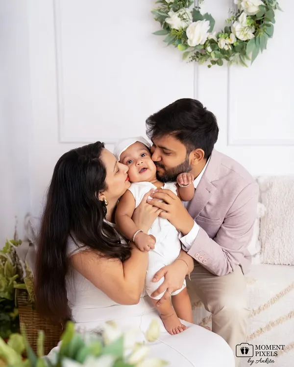 This is what it's all about. Capturing the pure, unscripted love that fills a room when a family comes together. This beautiful family portrait shows a mother and father cherishing their little one in a moment of perfect happiness.