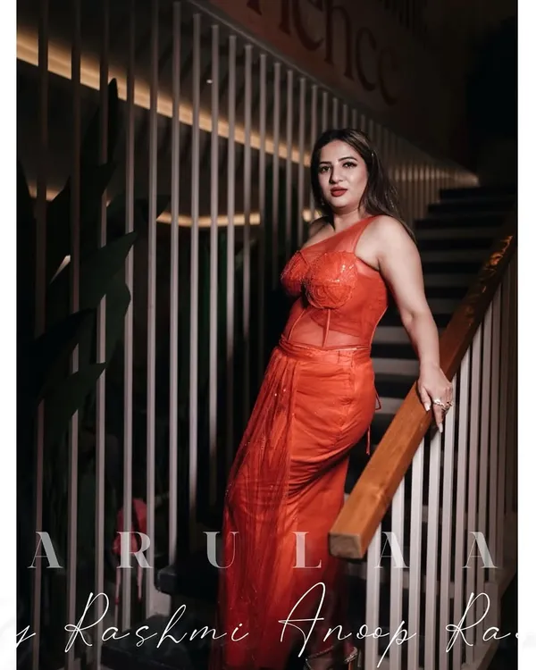 For actress Kaavya Sha, I designed this fiery red-orange fusion outfit. It features a corset-style boned top and a pre-draped skirt made of sequined fabric, creating a look that is both structured and glamorous.