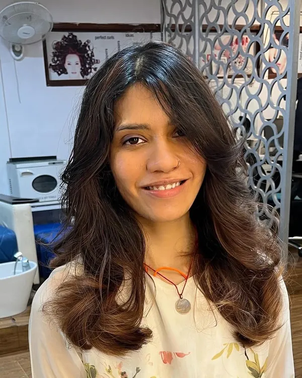 For Shruti, I created these beautiful butterfly layers that work with both her natural curly texture and when styled straight. Here she is looking happy with her versatile new cut.