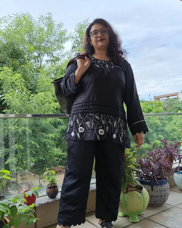 This hand-embroidered co-ord set in black modal satin is the perfect blend of sophistication and comfort. The top features delicate floral embroidery, and the pants have a stylish scalloped hem.