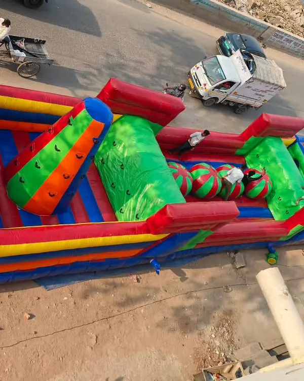 This is our massive 95-foot inflatable obstacle course, seen from above to show its full scale. It's a major attraction for large events, featuring multiple challenges like climbing sections, rollers, and a final climbing wall, all made from tough SRF fabric.