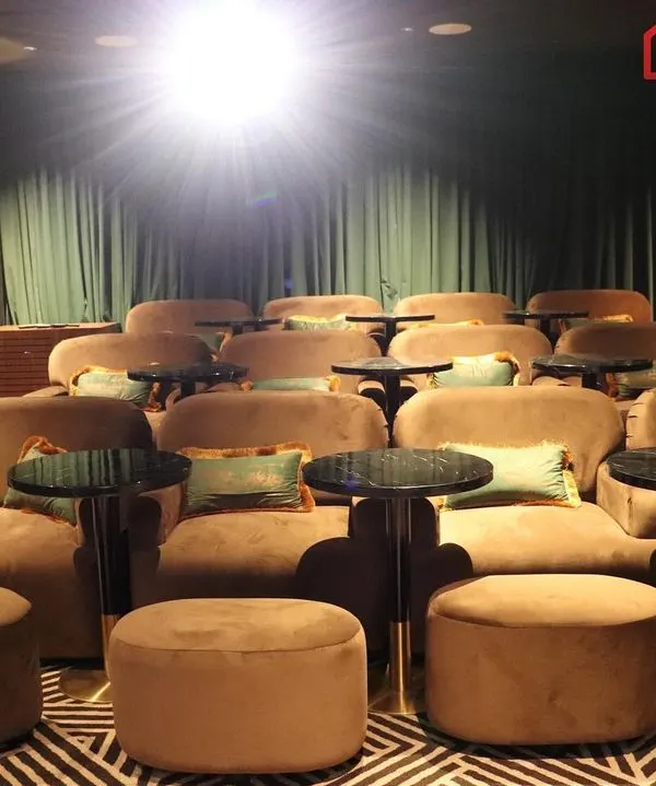This is the pinnacle of home entertainment, a super luxury home cinema designed for a VIP client. Notice the individual plush lounge chairs, each with its own side table, creating a personal and exclusive viewing experience reminiscent of a classic, high-end movie palace.