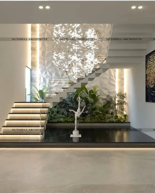 We transformed this triple-height stairwell into a breathtaking feature. A custom 3D wall panel serves as a dramatic backdrop, with a lush green space at the base and a sculptural chandelier that cascades down, creating a true work of art.