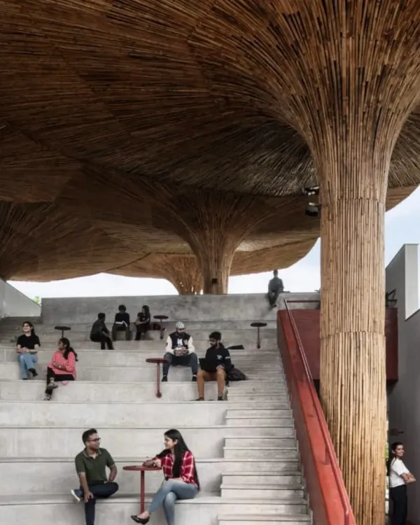 Students and faculty gather at the TAPMI Centre's amphitheater. This space is the heart of the project, designed to be a democratic forum for exchange, sheltered by an intricate canopy of bamboo that filters light like a forest.
