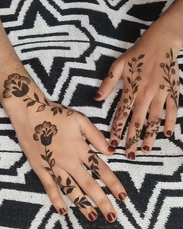 A perfect example of a minimalist henna design. The simple, spaced-out floral vines are delicate and graceful, adding a touch of beauty without being overwhelming.