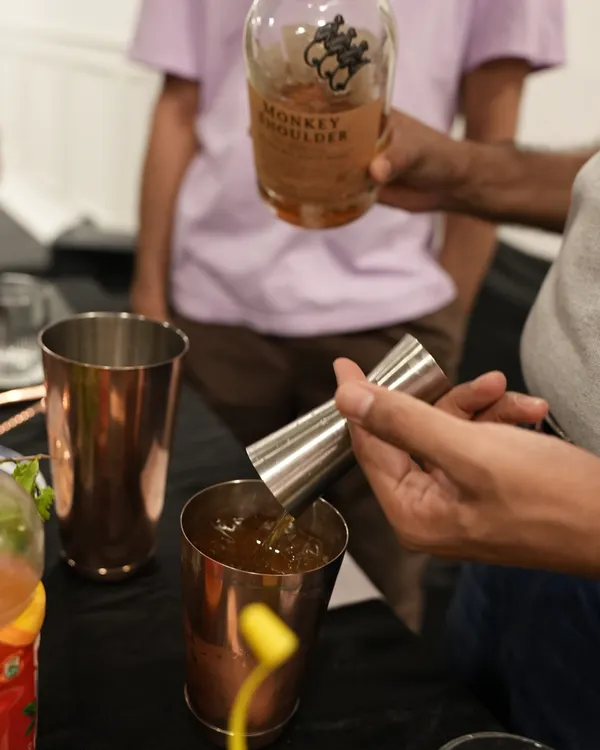 It all starts with quality ingredients. Here, we're measuring out Monkey Shoulder whisky with a jigger, a key tool for ensuring every cocktail is perfectly balanced. We teach you the importance of precise measurements for a consistent, delicious drink every time.
