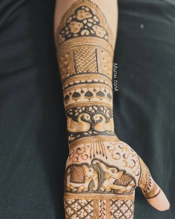 This forearm design is a beautiful showcase of traditional motifs. It features a pair of loving swans, majestic elephants, and an ornate dome pattern at the top.