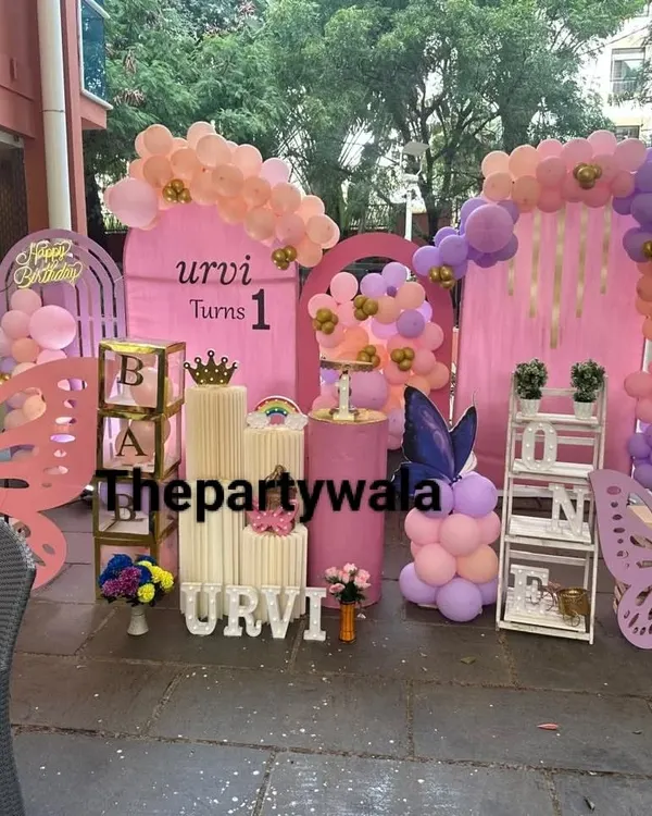 An absolutely stunning outdoor butterfly theme party. This large-scale setup features multiple pink backdrops, huge wooden butterfly cutouts, and beautiful pastel balloon arrangements.