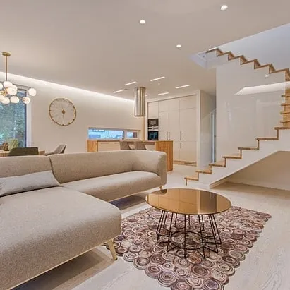 A bright, open-plan living space with clean white walls and a painted staircase. I handle complex interior projects that require a consistent, high-quality finish across multiple areas.