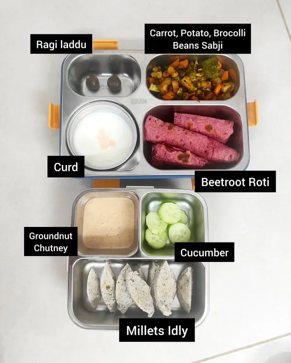 Here's a lunchbox idea with a mix of textures and flavors. It includes millets idly with groundnut chutney, beetroot roti for a colorful twist, a vegetable sabji, cool curd, and a sweet ragi laddu for a healthy treat.