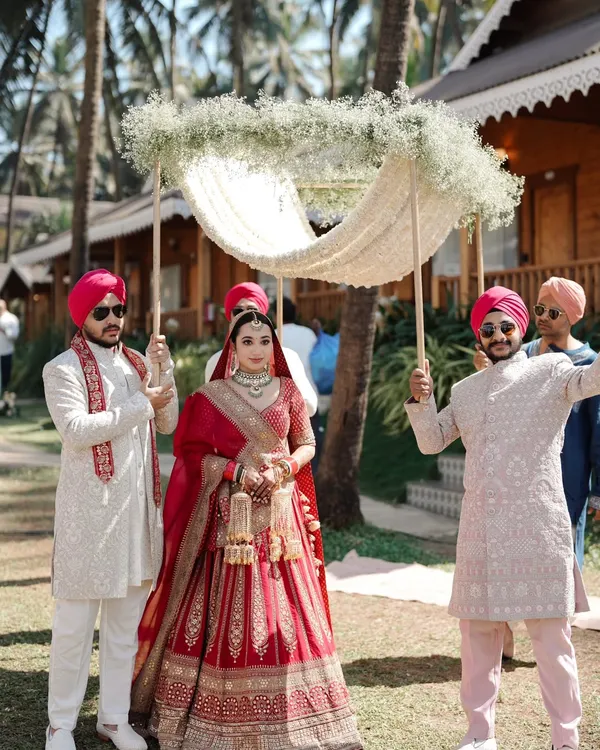 The grand bridal entry. We capture the bride's walk towards the mandap under a beautiful 'phoolon ki chadar' held by her brothers.