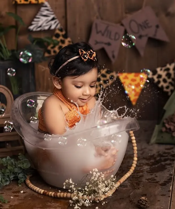 A joyful splash in the tub! This little one is having the time of her life during her jungle-themed bath session. The genuine splashes and giggles make for the best photos.