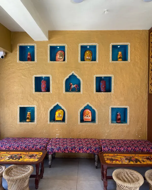 This finished wall at Rasodu restaurant in HSR Layout shows how traditional design can create a warm, rustic ambiance. The combination of the textured ochre wall and the vibrant blue niches makes for a memorable feature wall.