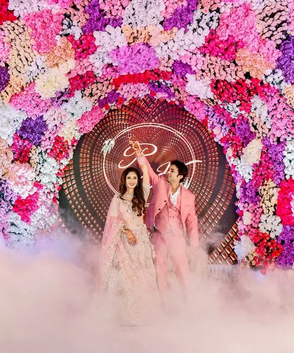 A fairytale entrance for a love story written in the stars. The couple emerges through a cloud of smoke under a magnificent floral arch, ready to celebrate their union. This is the kind of cinematic moment that defines a grand engagement.