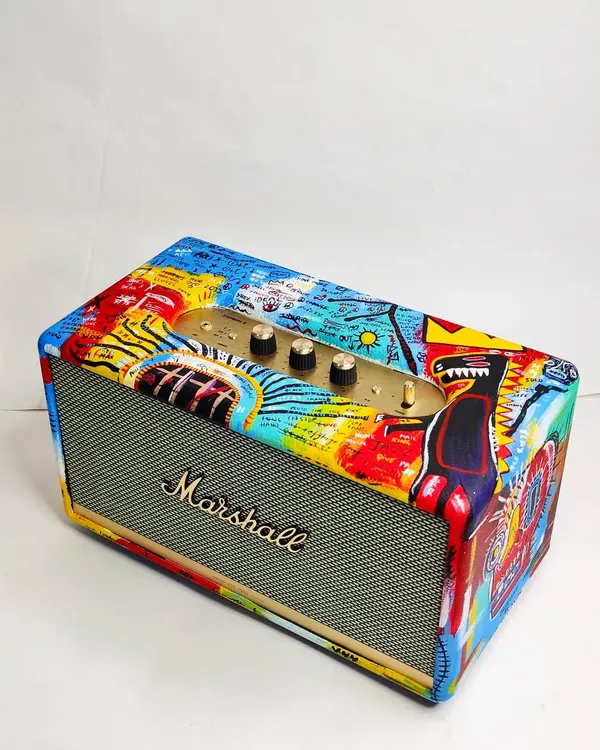 A full view of the custom-painted Marshall speaker. I covered the entire surface with a vibrant, freehand mashup of elements inspired by the artist Basquiat, turning a functional object into a statement art piece.
