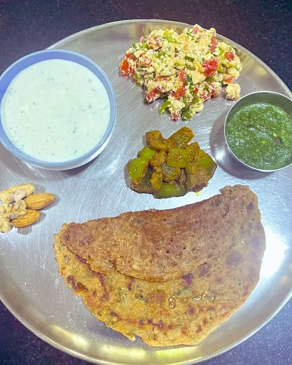 This is my ideal plate for breaking a fast. It features a moong dal and almond flour chila, paneer bhurji, capsicum masala, and cucumber raita. It's packed with protein and healthy fats to nourish the body.