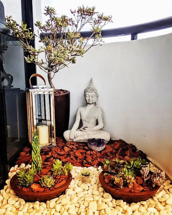 This is a classic zen corner I designed for a client. It features a meditating Buddha statue, a collection of low-maintenance succulents, and a mix of white pebbles and bark chips for texture, creating a calm and earthy display.