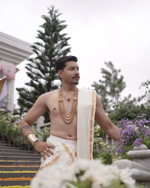 A groom with a regal presence. He is wearing a traditional multi-layered antique necklace, perfect for a South Indian muhurtham ceremony.