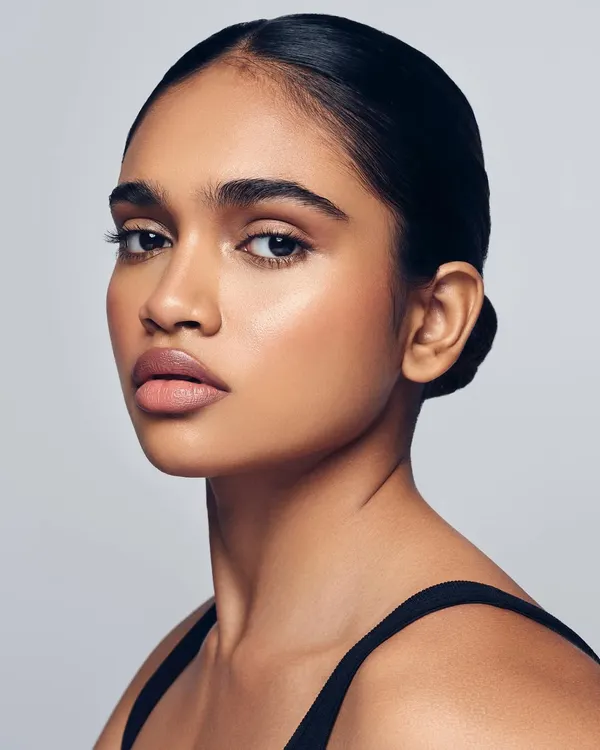 The perfect example of 'Snatural' glam. This look combines a naturally sculpted face with a clean, luminous skin finish and a sleek bun for a sophisticated and modern aesthetic.