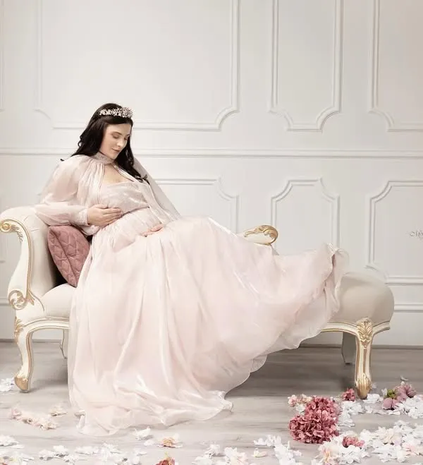 This is more than a photograph; it's a story of royalty, grace, and the magnificent journey of motherhood, captured in a timeless Victorian-inspired setting.