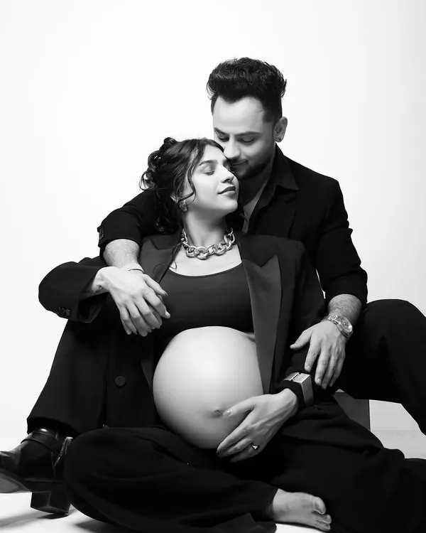 A modern and chic maternity portrait. The choice of matching black blazers creates a powerful, stylish look, while the black and white photography adds a timeless, intimate feel to the moment.