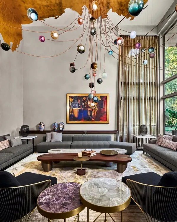 A living room from our Baid Residence project, where we layered textures and art to create a space that is both grand and intimate. The design features a custom gold leaf ceiling, a dramatic Bocci light installation, and furniture from Minotti and Poliform, all centered around a captivating artwork by Paresh Maity.