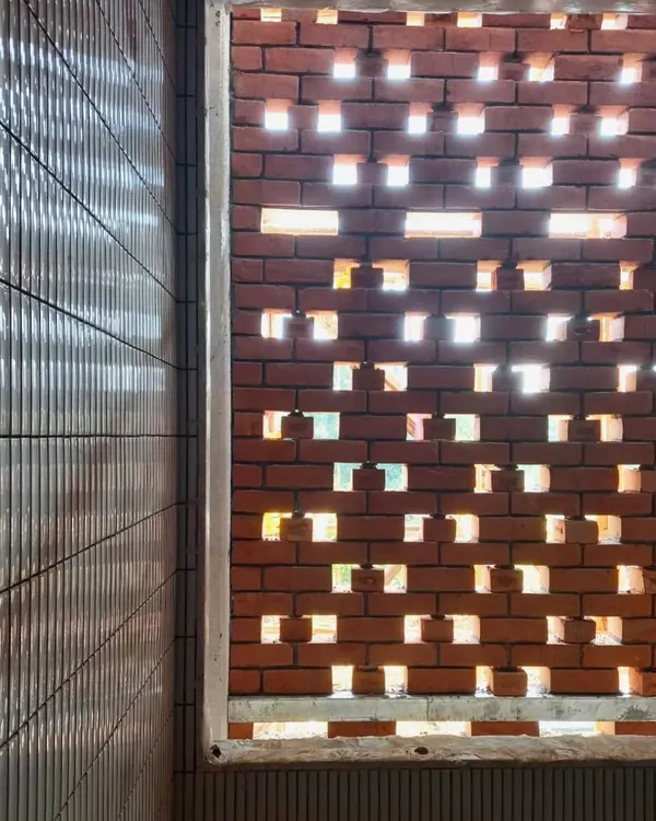 A close-up of the perforated brick screen at our Kolgaon Masterplan project, seen during construction. This image shows how the pattern of the brickwork is designed to filter light and create a dynamic play of shadows.