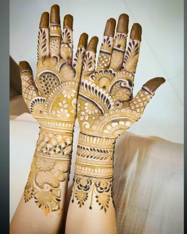 A different angle of a peacock-themed bridal mehandi, showing the details on the fingers and wrist.
