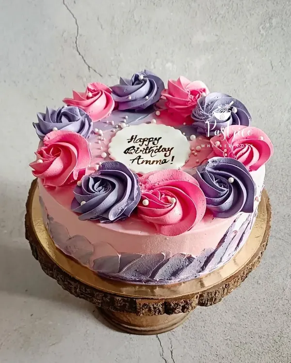 A floral strawberry cake made for a very special mother. The combination of pink and purple buttercream rosettes on a soft, fresh strawberry cake is one of my favorite designs to create.